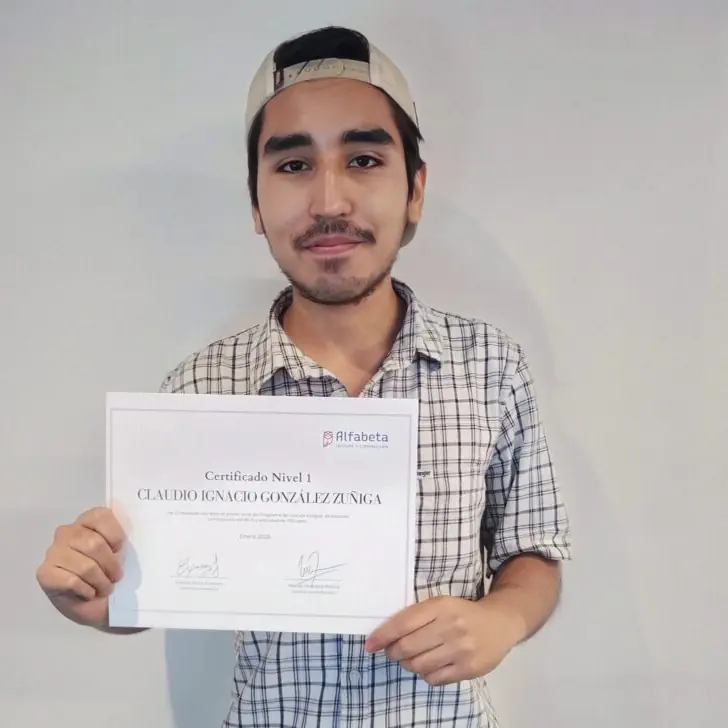 Alumno joven sosteniendo su diploma de Alfabeta con una expresión de seguridad y triunfo.