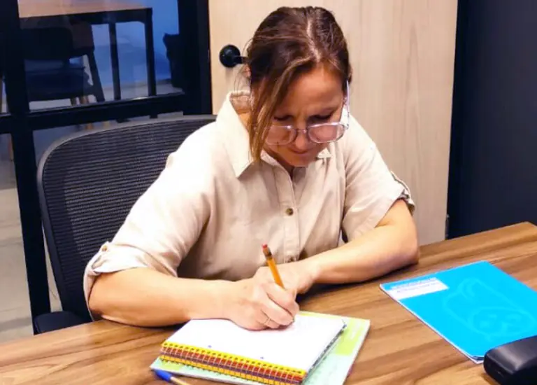 Profesora revisando métricas de velocidad y comprensión lectora en su estación de trabajo.